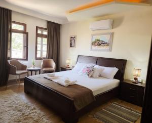 a bedroom with a large bed and two chairs at Hotel Taraca Gorice - UNESCO quarter in Berat