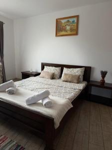 a bedroom with a bed with two towels on it at Complex Turistic Brândușa in Avrig