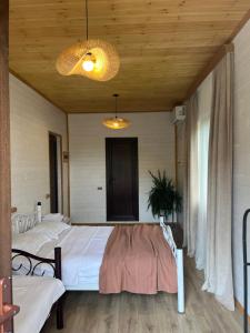 two beds in a room with wooden ceilings at Balda Novel House in Martvili