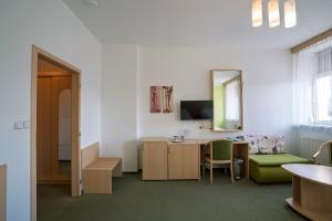 a room with a desk and a chair and a mirror at Hotel Senimo in Olomouc