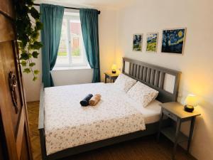 a bedroom with a teddy bear sitting on a bed at Škorničkův statek - chalupa Andělka s wellness za příplatek in Hamr