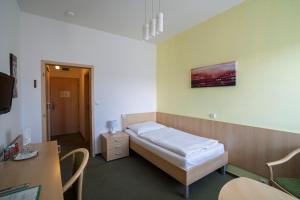 a hospital room with a bed and a desk at Hotel Senimo in Olomouc +34 photos