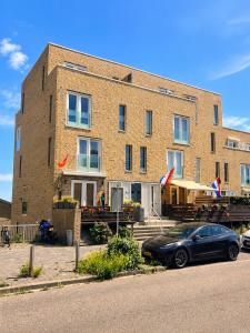 a building with a car parked in front of it at Beach Villa & Studio in Zandvoort