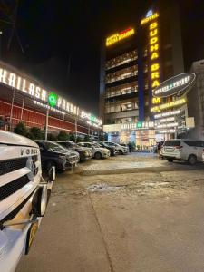 a parking lot with cars parked in front of a building at Hotel Sudha Brahma in Tirupati