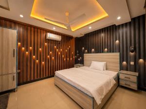 a bedroom with a bed and a wall with lights at The Comfy By Hotel Mountain Track in Taranna