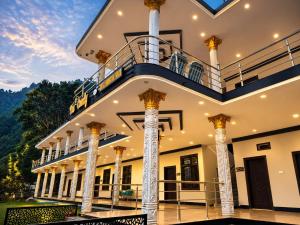 a large building with columns and a balcony at The Comfy By Hotel Mountain Track in Taranna