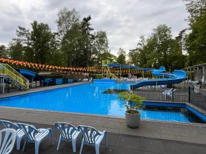 a large swimming pool with a water slide at Chalet Bosrand 42 Park Veluwshof 6 p in Hoenderloo