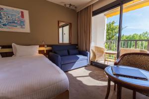 a bedroom with a bed and a couch and a table at Villa Borghese, The Originals Relais in Gréoux-les-Bains +33 photos