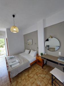 a bedroom with a bed and a mirror and a table at Mirsini Rooms in Votsi