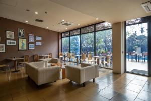 a restaurant with chairs and tables and large windows at Radisson Blu Dhaka Water Garden in Dhaka