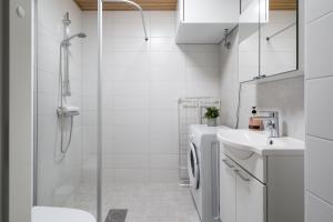 a bathroom with a shower and a toilet and a sink at Hiisi Homes Järvenpää in Järvenpää +45 photos