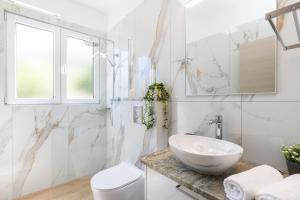 a white bathroom with a sink and a toilet at Apartment Jakov Grscica in Prizba +57 photos