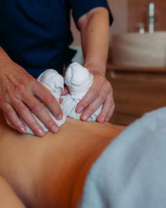a man is applying moisturizers on a persons arm at Villa Borghese, The Originals Relais in Gréoux-les-Bains