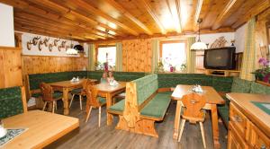 a restaurant with tables and chairs and a tv at Ringlerhof in Michaelerberg