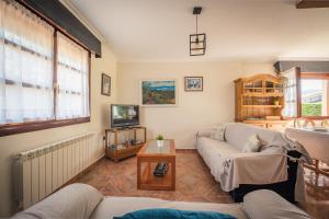 a living room with a couch and a tv at Casa Rural El FerJo in Colunga
