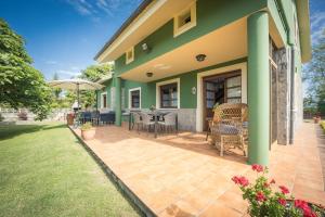 a patio of a house with a table and chairs at Casa Rural El FerJo in Colunga