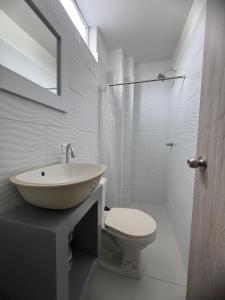 a white bathroom with a sink and a toilet at karolina Real Hotel Experience in Apartadó +17 photos