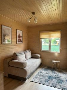 a living room with a couch and a window at Agroturystyka nad Jeziorem Orłowskim in Wielgie