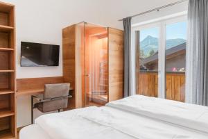 a bedroom with a bed and a desk and a window at Appartementhaus Reiter in Altenmarkt im Pongau