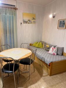 a room with a bed and a table with chairs at Green Quiet Apartments in Vodice
