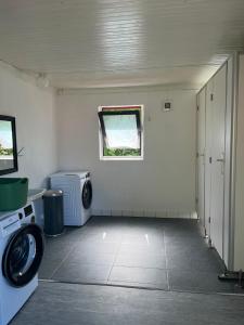 a laundry room with a washing machine and a window at Lystang Camping & Cabins in Notodden