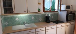 a kitchen counter with a sink and a microwave at Large Spacious House In Fréjus in Fréjus