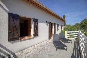 a patio with chairs and a building with a fence at Large Spacious House In Fréjus in Fréjus