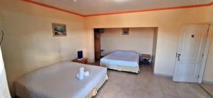 a bedroom with two beds and a door to a room at Canto do Atlântico Hotel in Guarujá +20 photos