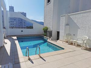 a swimming pool on the side of a building at Canto do Atlântico Hotel in Guarujá