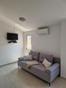 a living room with a couch and a tv at Apartmani AE in Biograd na Moru