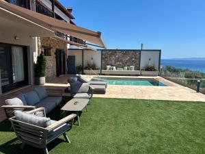 a house with a yard with a pool and grass at Elia Luxury House in Ouranoupoli