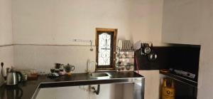 a small kitchen with a sink and a window at Queens luma villa in Arugam Bay