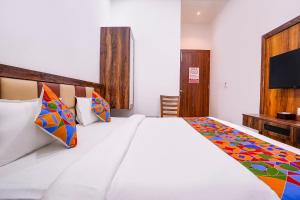 a bedroom with a large white bed with colorful pillows at FabHotel Elvis International in Mumbai +39 photos
