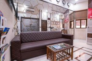 a living room with a couch and a table at FabHotel Elvis International in Mumbai