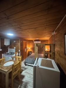a kitchen and dining room with a table and a refrigerator at Cabañas las fulanas in Villa Giardino