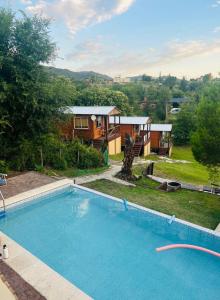 a large swimming pool in front of a house at Cabañas las fulanas in Villa Giardino