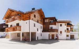 a large white building with a wooden roof at Appartementhaus Reiter in Altenmarkt im Pongau