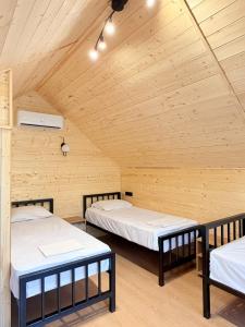two beds in a room with a wooden ceiling at Siran Guest House in Areni