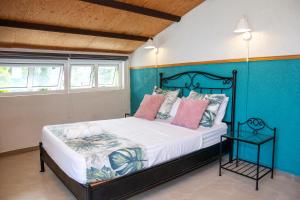 a bedroom with a bed with a blue wall at Mermaid Cove - Blue Bay in Blue Bay