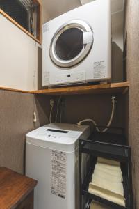 a washer and dryer in a small kitchen at Konrai Hotel Matsumoto in Matsumoto