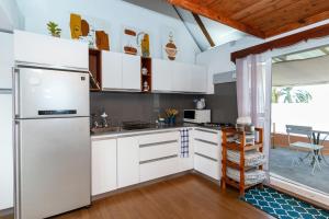 a kitchen with white cabinets and a refrigerator at Mermaid Cove - Blue Bay in Blue Bay