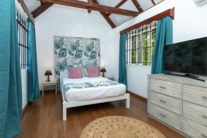 a bedroom with a bed and a flat screen tv at Mermaid Cove - Blue Bay in Blue Bay +12 photos