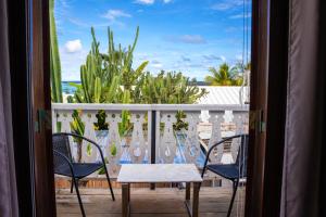 a room with a balcony with a table and chairs at Mermaid Cove - Blue Bay in Blue Bay