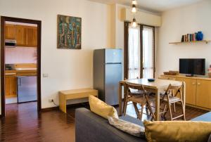 a kitchen and a living room with a table and a refrigerator at Barzio Coldogna 5 in Barzio