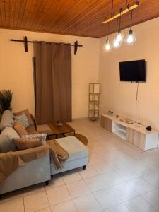a living room with a couch and a flat screen tv at Panorama in Porto Rafti
