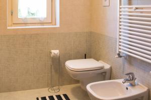 a bathroom with a toilet and a sink at Alpine studio Barzio in Barzio