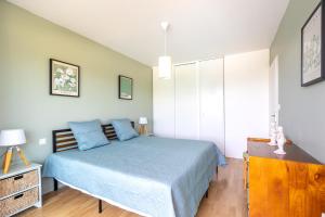 a bedroom with a blue bed and a wooden dresser at Green Flat - Appt proche des Sables dOlonnes in LʼAiguillon-sur-Vie +12 photos