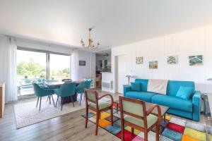 a living room with a blue couch and a table at Green Flat - Appt proche des Sables dOlonnes in LʼAiguillon-sur-Vie