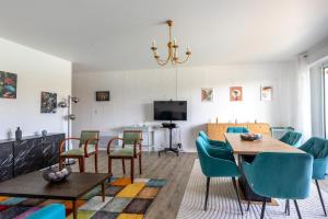 a living room with a dining room table and chairs at Green Flat - Appt proche des Sables dOlonnes in LʼAiguillon-sur-Vie