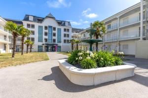 a large apartment building with a fountain in a park at Green Flat - Appt proche des Sables dOlonnes in LʼAiguillon-sur-Vie